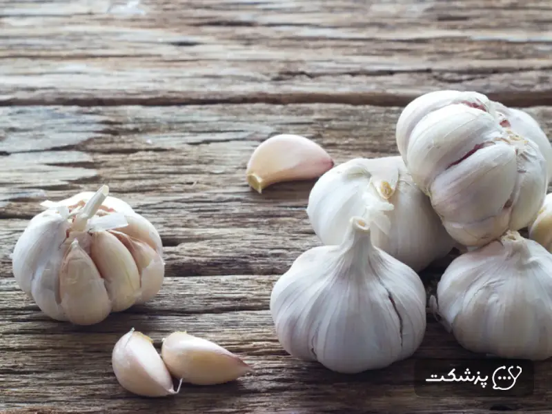 سیر تازه روی میز چوبی به عنوان داروی گیاهی ضد قارچ برای برفک واژن