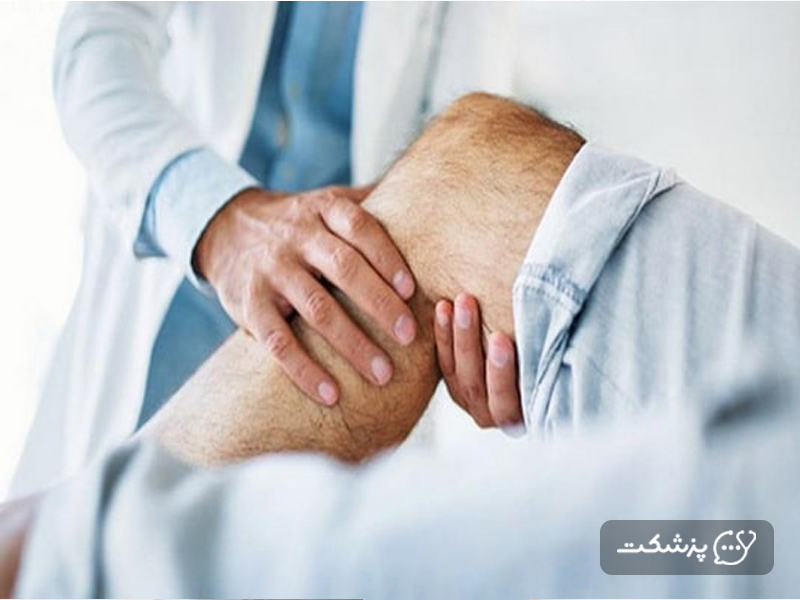 پزشک در حال معاینه پای بیمار